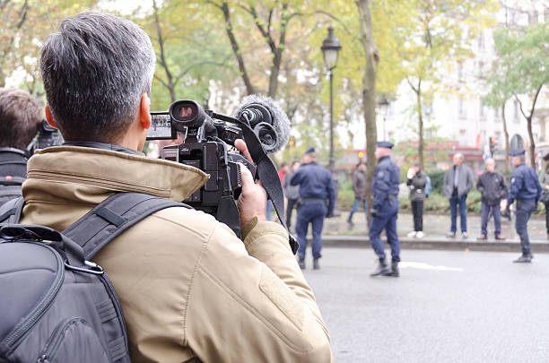 Periodista filmando a la policía alrededor del Bataclan durante el homenaje - foto de stock