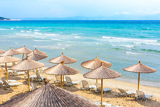 istock beach background with turquoise sea water waves and umbrellas, Greece 624286956