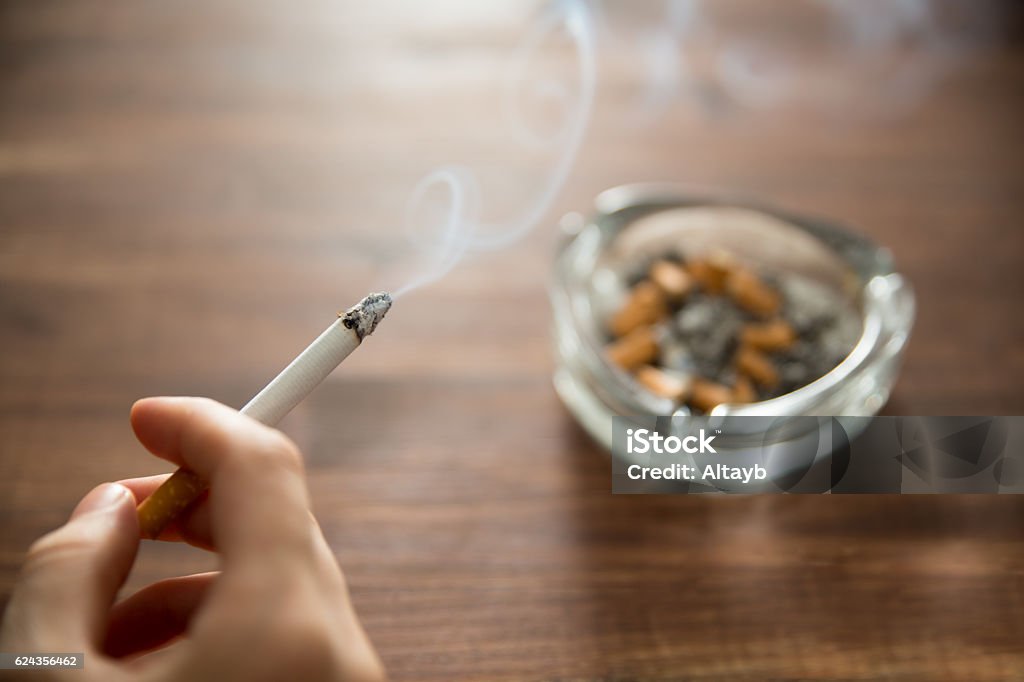 燃えるタバコを手に持つ若い女性 - タバコを吸うのロイヤリティフリーストックフォト