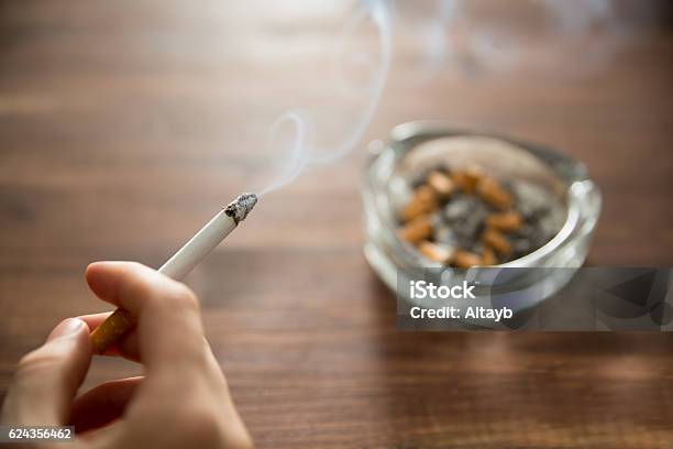 燃えるタバコを手に持つ若い女性 - タバコを吸うのストックフォトや画像を多数ご用意 - タバコを吸う, 喫煙問題, 煙