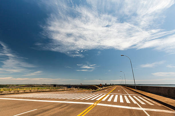 route vide sur les rives du barrage d’itaipu - itaipu dam photos et images de collection