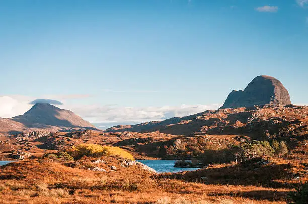 A landscape image looking across to Suilven and Canisp, mountains in Assynt, in the Scottish highlands.