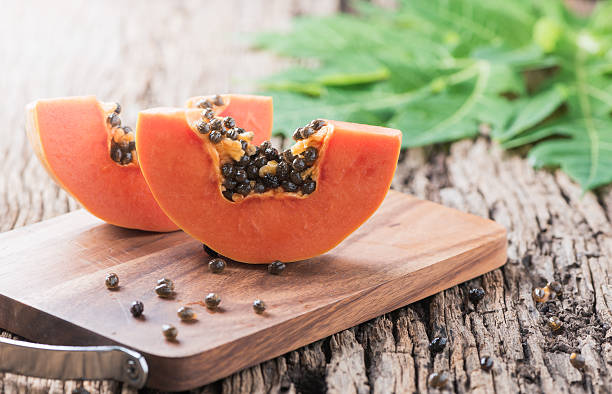 papaia affettata frutta fresca su blocco di legno - papaya foto e immagini stock