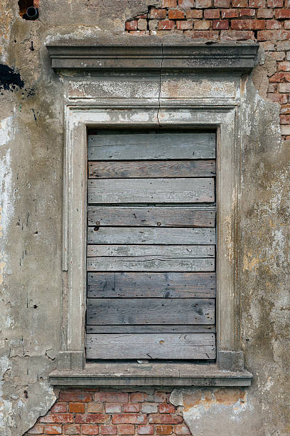 istock Old, boarded up window in the ruined wall 624374470