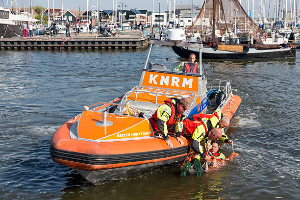 Urk, The Netherlands - September 24, 2016: Rescue workers at lifeboat showing how to save people out of the water in the harbor of Urk