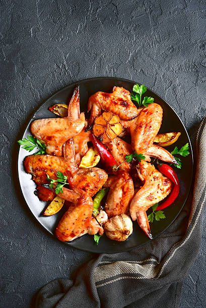 istock Grilled chicken wings on a black plate.Top view. 624389780
