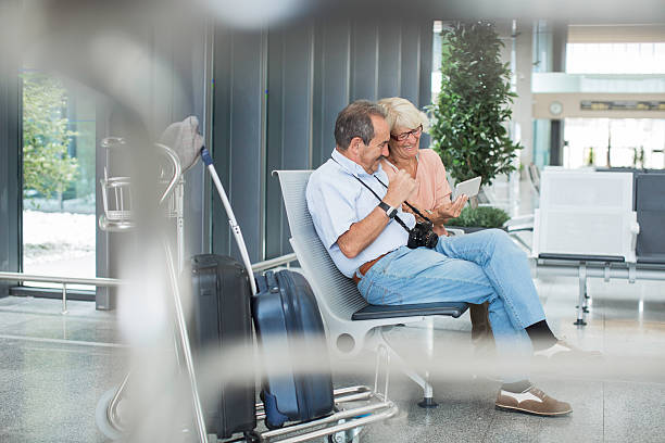 istock Couple waiting for plane departure and enjoying digital tablet. 624390876