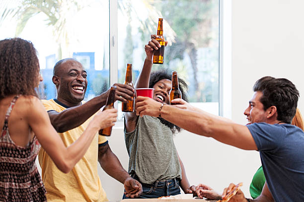 Group of friends in vacations enjoying pizza and beers
