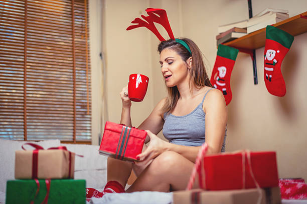 femme enceinte buvant du thé et tenant un cadeau de noël - joy the human body smiling women photos et images de collection