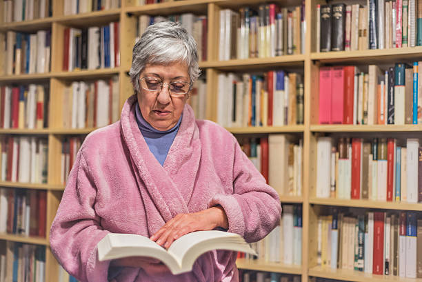 istock Senior woman reading a book at home. concentrated expression. 624404132