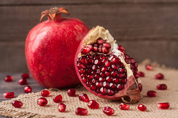 istock pomegranate on the old wooden board with sackcloth 624405238