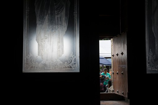 Oaxaca, Mexico - October 31, 2014: View from inside the Cathedral of Our Lady of the Assumption in the Mexican city of Oaxaca, looking out the door toward people using mobile phones outside.