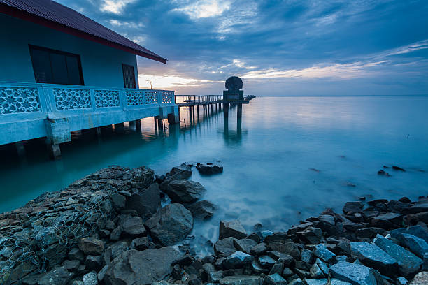 istock Sunrise by shore with rock foreground for background 624411048