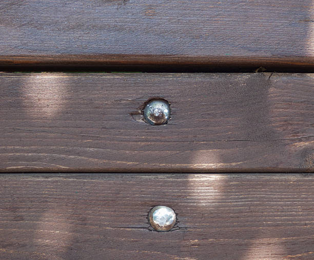 istock Hardwood wall surface. Brown boards with silver screw heads 624411404