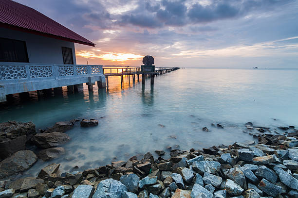 istock Sunrise by shore with rock foreground for background 624411606