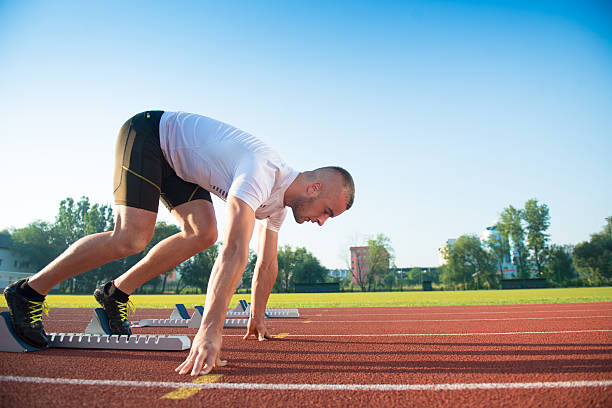 istock Male athlete on starting position at athletics running track. 624435098