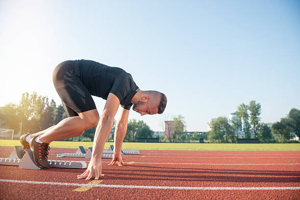 istock Male athlete on starting position at athletics running track. 624436030