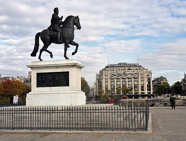 Paris, France - November 5, 2010: the equestrian statue of King Henry IV on the Pont Neuf, built by his wife Maria De Medici in 1614 after the assassination of the king and replaced today. In the background the La Samaritaine Department Store, built in the late nineteenth century Art Nouveau.