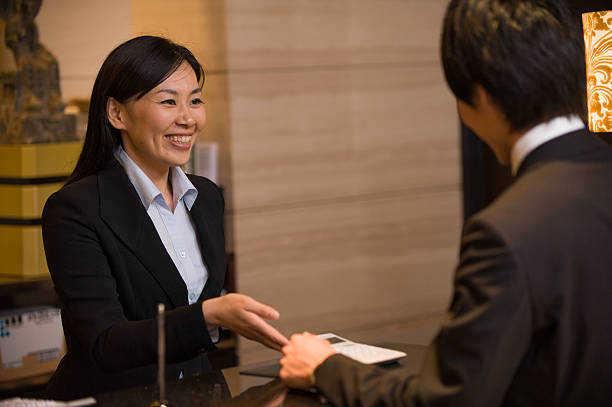 Asian Concierge in Hotel with Customer stock photo