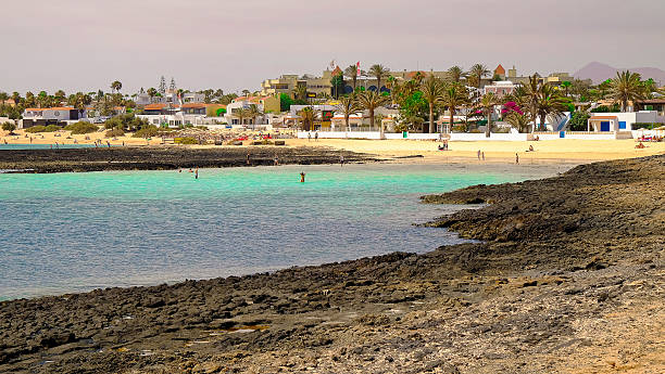 vista na praia de corralejo, fuerteventura, espanha. - volcanic landscape rock canary islands fuerteventura - fotografias e filmes do acervo