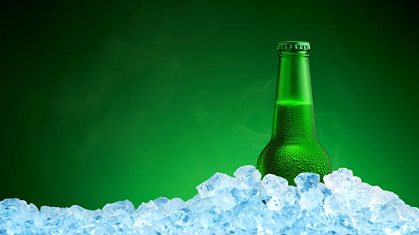 istock Bottle of cold beer in ice on green background 624438180