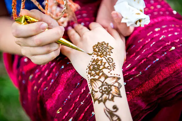 Picture of human hand being decorated with henna Tattoo. mehendi hand