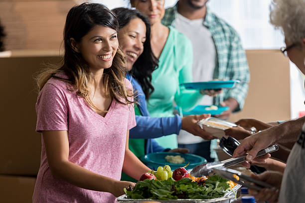istock Volunteers serve people in soup kitchen 624441568