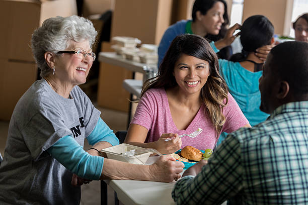 istock Soup kitchen volunteers share meal together 624441762