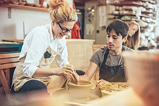 istock Man and woman in workshop working on pottery wheel 624443578