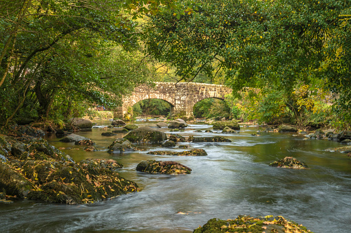 Landscape depicting the beautiful meandering River Teign on a bright Autumn day. Image taken at Fingle Bridge near Castle Drogo in the Dartmoor National Park,, Chagford, Devon, England.
