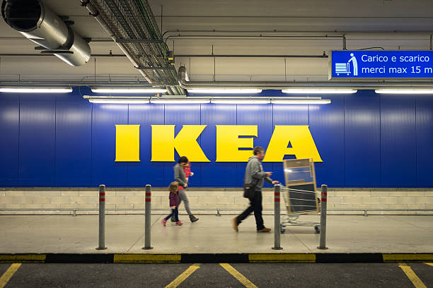 Family Walking At Ikea Store After Shopping Chieti, Italy - November 19, 2016: A family walking in the car parking after shopping at Ikea store; the big sign of the store is in the background. Ikea is one of the largest (if not the largest)  ready-to-assemble furniture retailer. abruzzi photos stock pictures, royalty-free photos & images