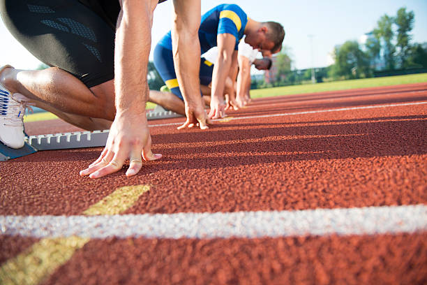 트랙에서 경주 할 준비가된 사람들의 클로즈업 사이드 뷰 - rivalry starting block track and field athlete track and field 뉴스 사진 이미지