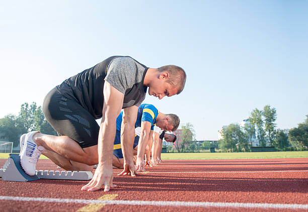 트랙에서 경주 할 준비가된 사람들의 클로즈업 사이드 뷰 - rivalry starting block track and field athlete track and field 뉴스 사진 이미지