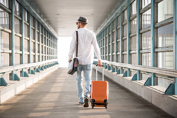 istock Hipster Male Walking on Bridge with Suitcase 624458462