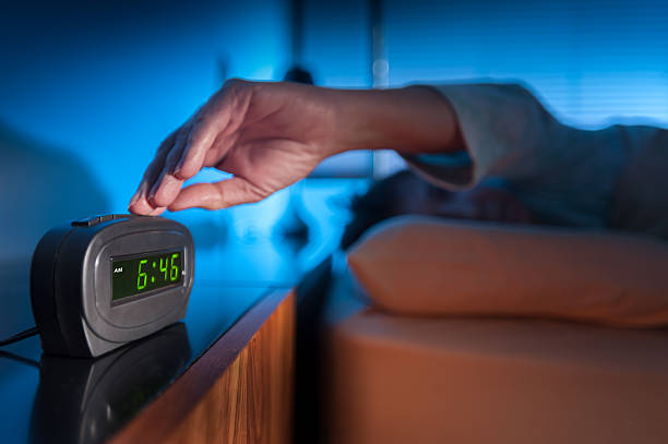 Wake up alarm Woman pressing snooze button on early morning digital alarm clock alarm clock snooze stock pictures, royalty-free photos & images