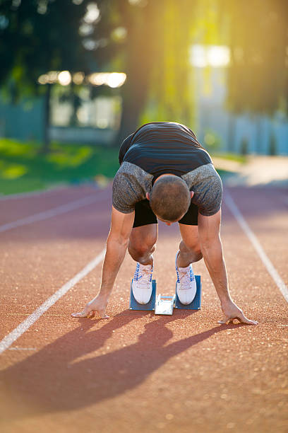 istock Athletic man on track starting to run. 624472212
