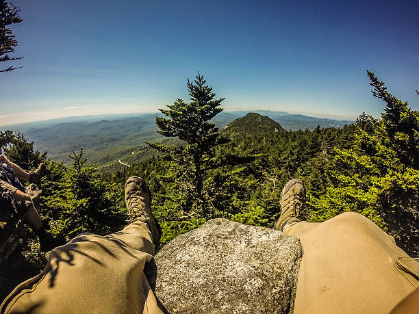istock Hiker legs and boots view on the mountain peak relaxing 624473366