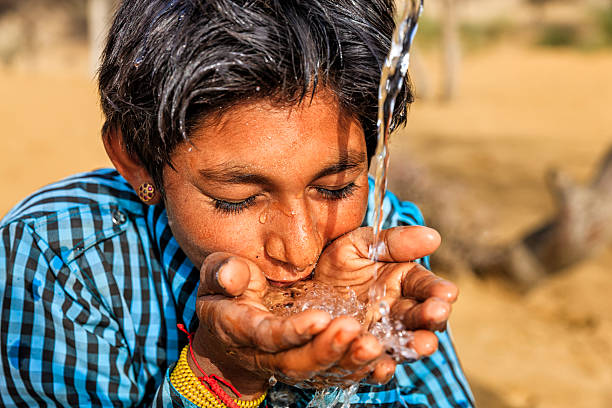 istock Indian young boy drinking fresh water, desert village, Rajasthan, India 624475290