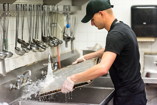 young dishwasher working at a restaurant kitchen