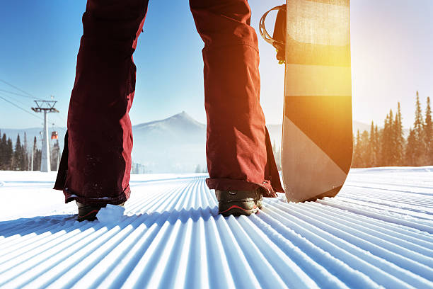 snowboarder stands on slope backdrop - snowboard boot imagens e fotografias de stock
