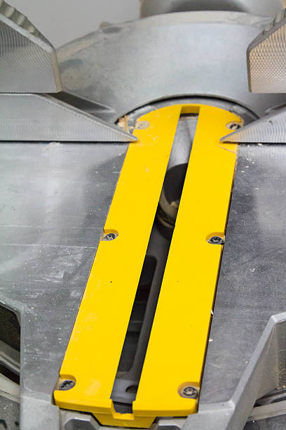 Yellow slot for the blade on a miter saw A bright yellow slot for the blade on a miter saw, close up.   The slot is on the table of the miter saw and the yellow zone is meant to be a keep out zone for fingers. miter saw stock pictures, royalty-free photos & images