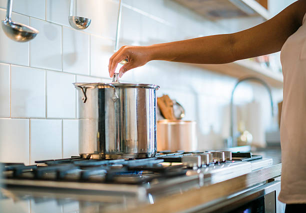 istock Young pretty black woman make soup in kitchen 624490954