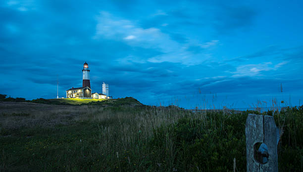 Montauk Point Lighthouse, sunset. Long Island, New York State, USA. Scenic view to the Montauck Point Lighthouse at sunset, with dramatic sky and bright colors. Montauk, Long Island, USA, montauk point stock pictures, royalty-free photos & images