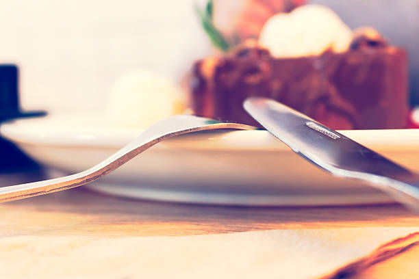 Close up fork and knife on dish with icecream chocolate.
