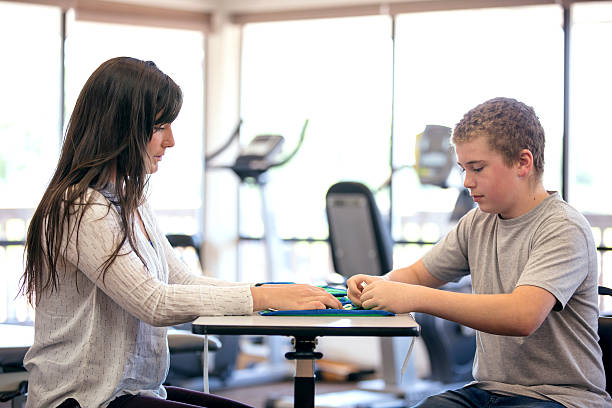 istock Young boy working with a female therapist during rehab 624493830
