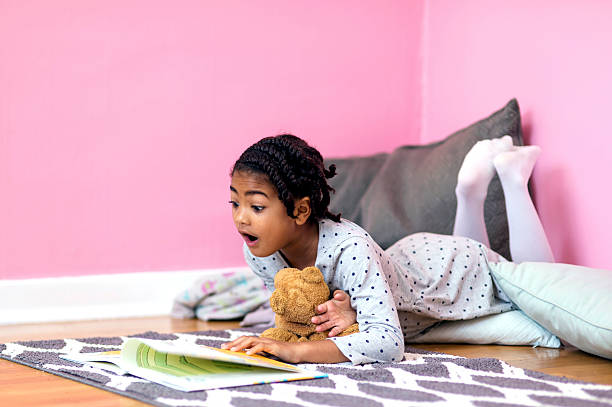istock Cute African American girl reading an exciting book 624494556