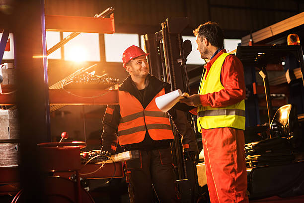 istock Two mid adult metal workers communicating in aluminum mill. 624497408