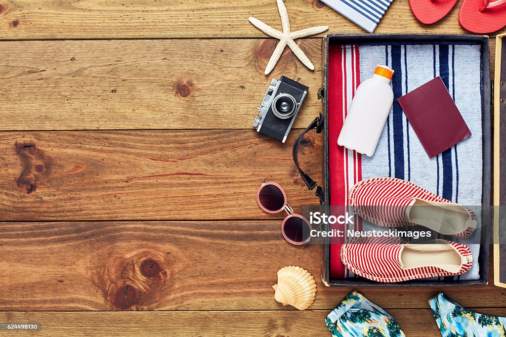 Maleta abierta y embalada con accesorios de vacaciones planas en el suelo - Foto de stock de Verano libre de derechos