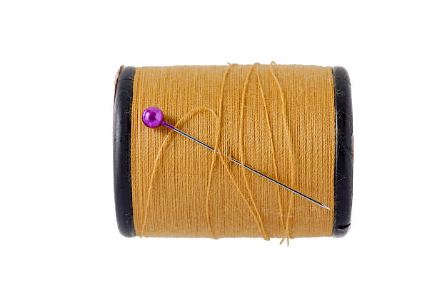 istock Pink sewing pins with brown bobbin thread on white background. 624498150