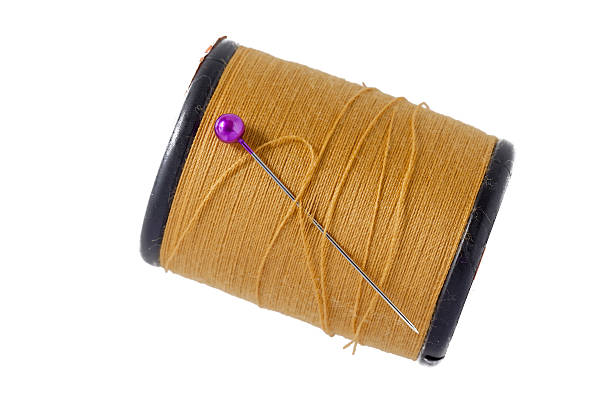 istock Pink sewing pins with brown bobbin thread on white background. 624498226